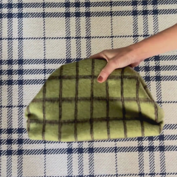 Olive windowpane + carmel | black
Carmel Patent Leather Trim.  Black and white pinstripe interior.
Green checkered clutch on a white background
