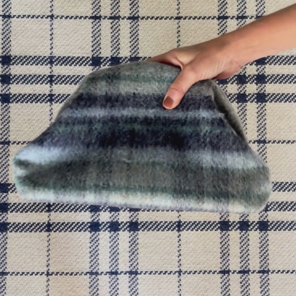 Navy tartan + green | grey
Olive Patent Leather Trim.  Navy and white pinstripe interior. Plaid-patterned clutch on a white background